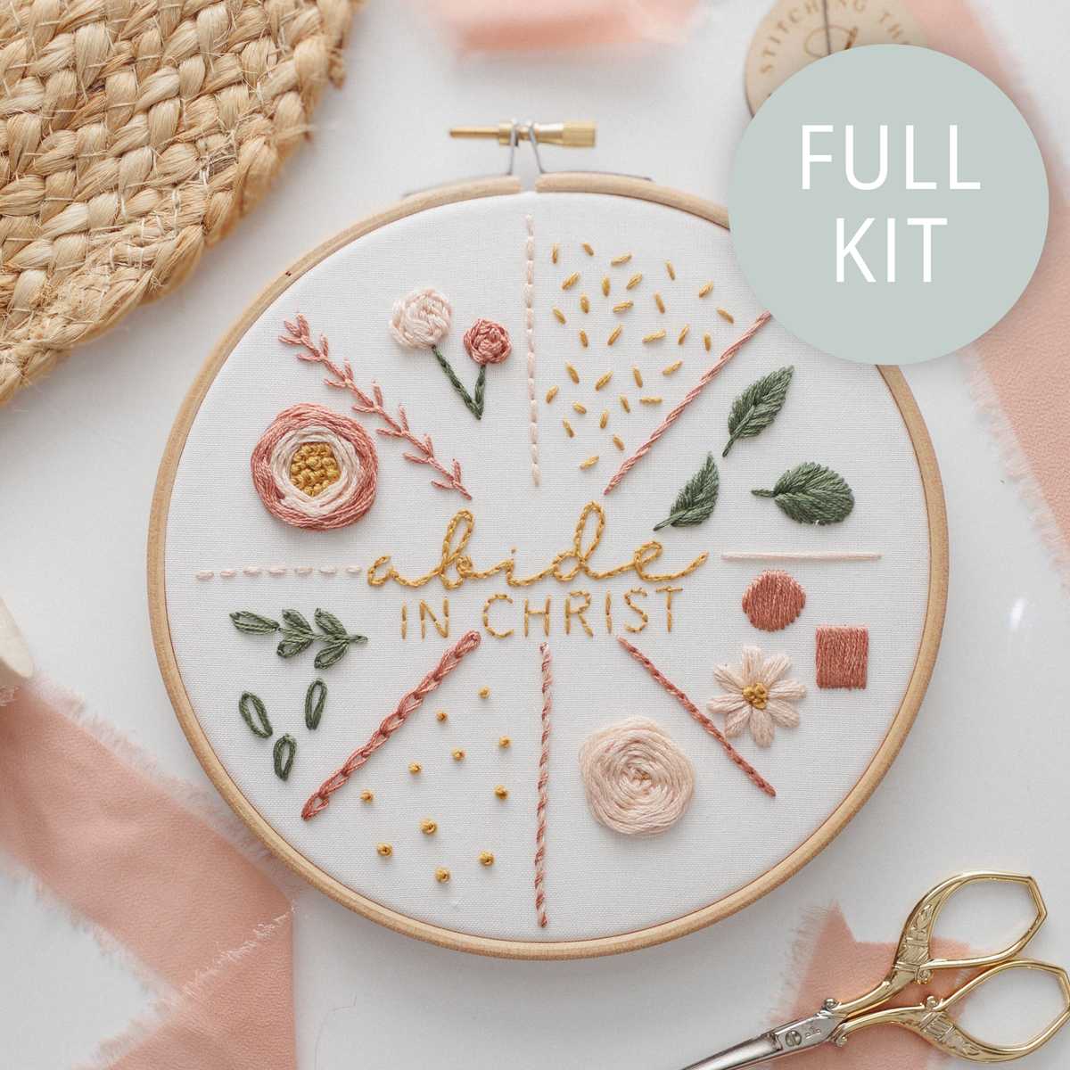 Finished stitch practice hoop: "abide in Christ" surrounded by flowers, leaves and stitch samples