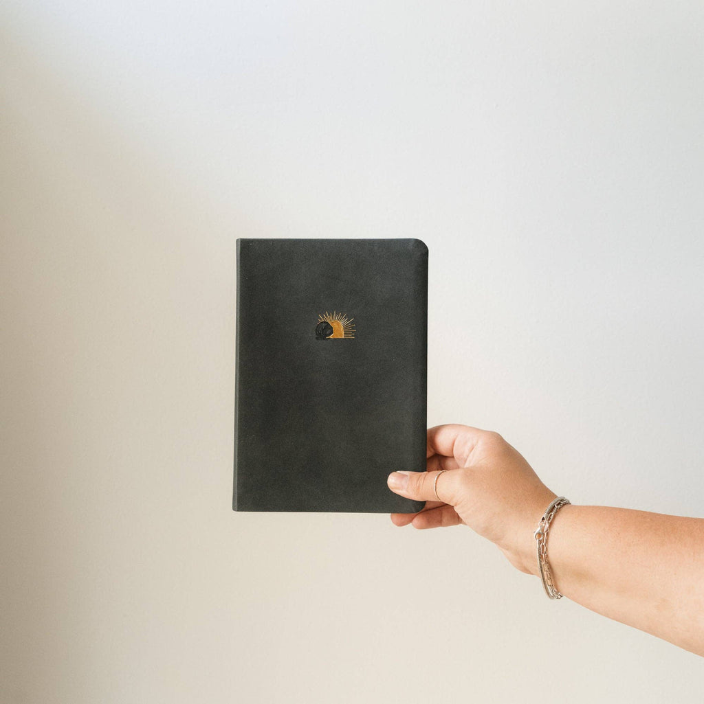Hand holding the black notebook
