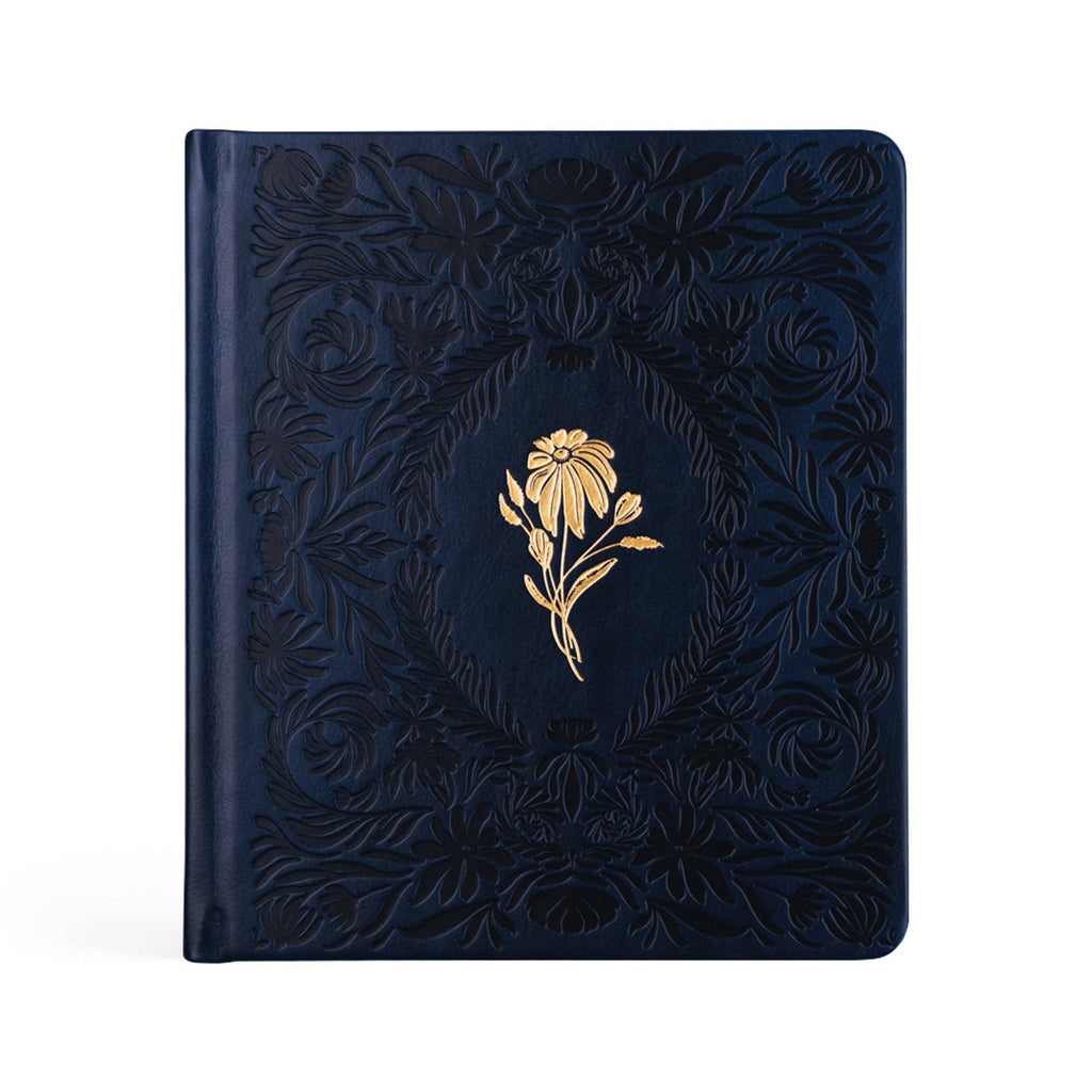 Navy faux-leather prayer journal with a debossed floral frame and a single gold flower