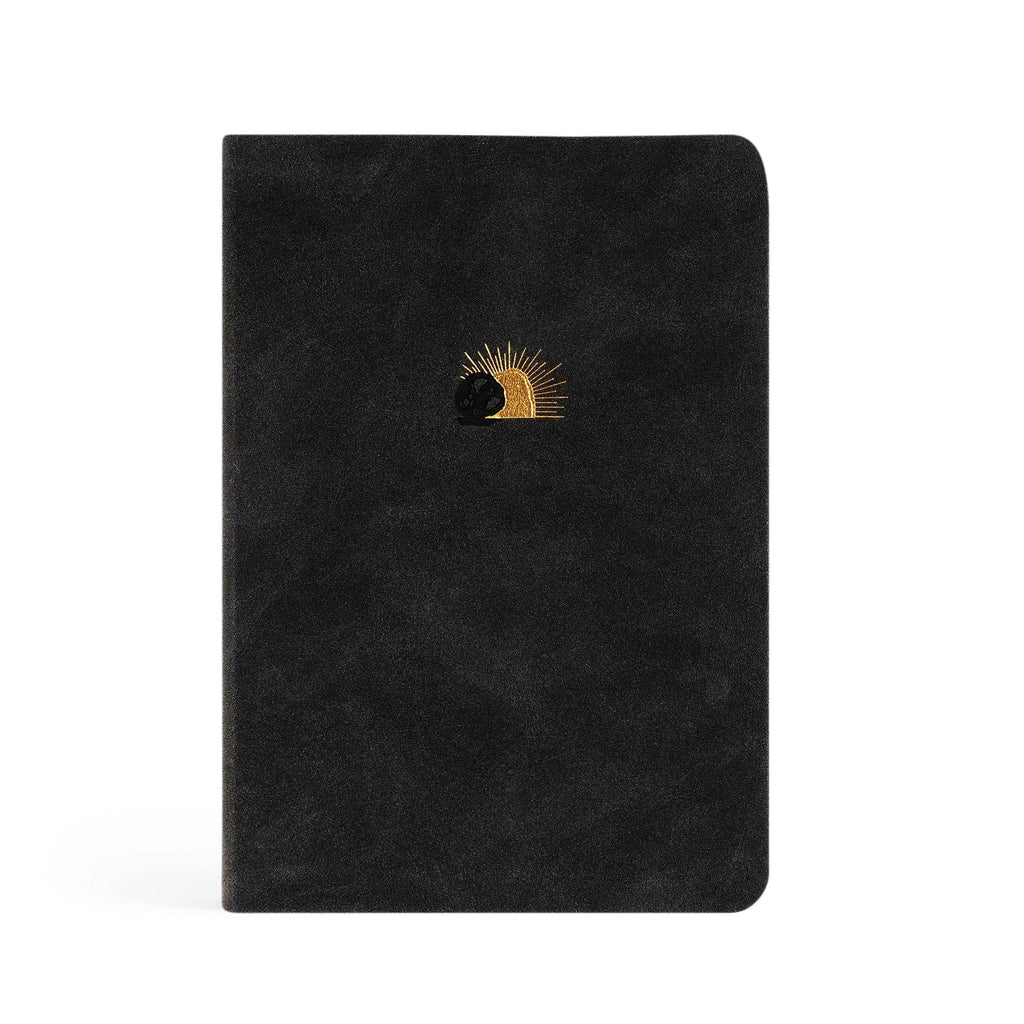 Black faux-suede notebook with a small gold sun rising behind a rolled-away stone
