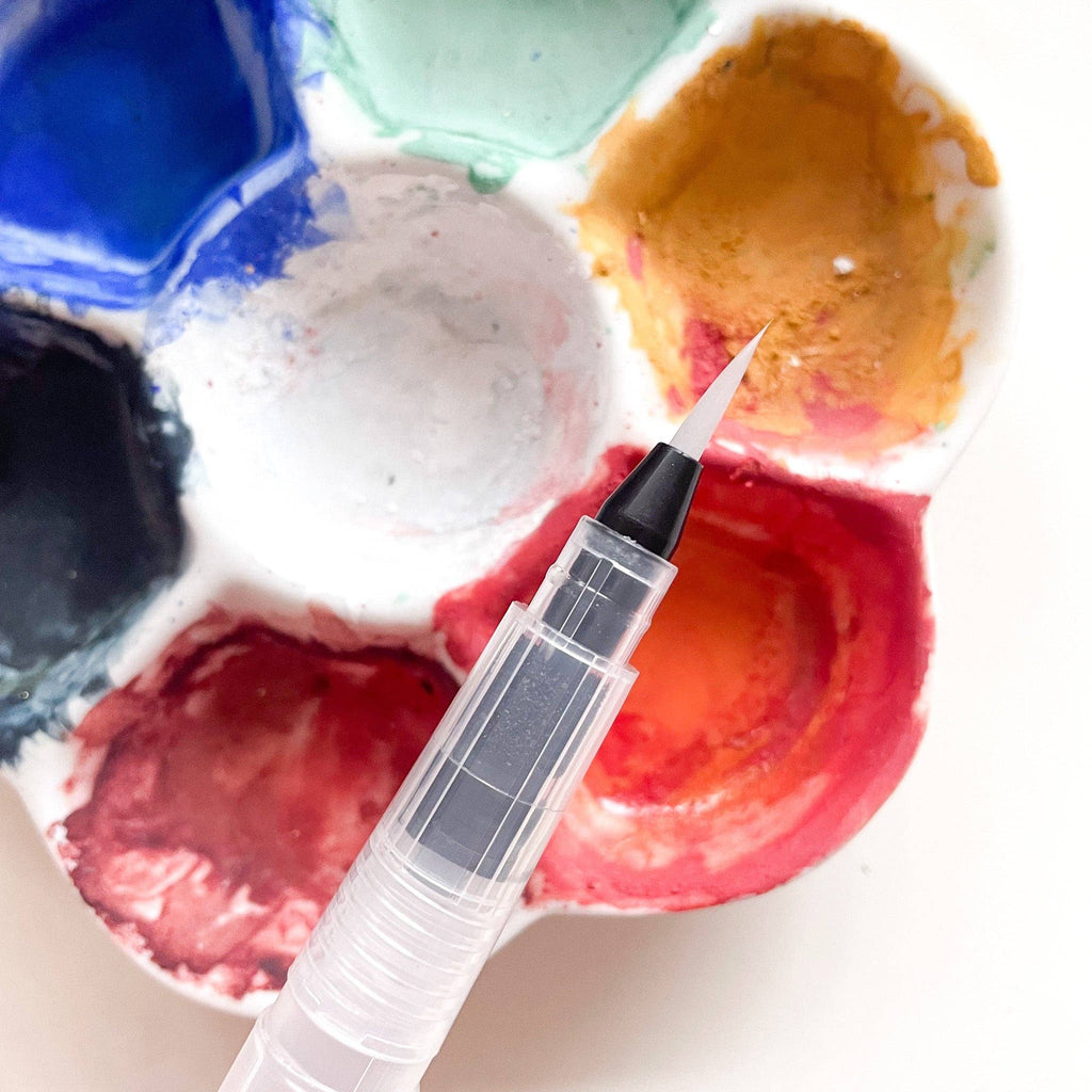 Close view of a water brush's fine tip over the palette