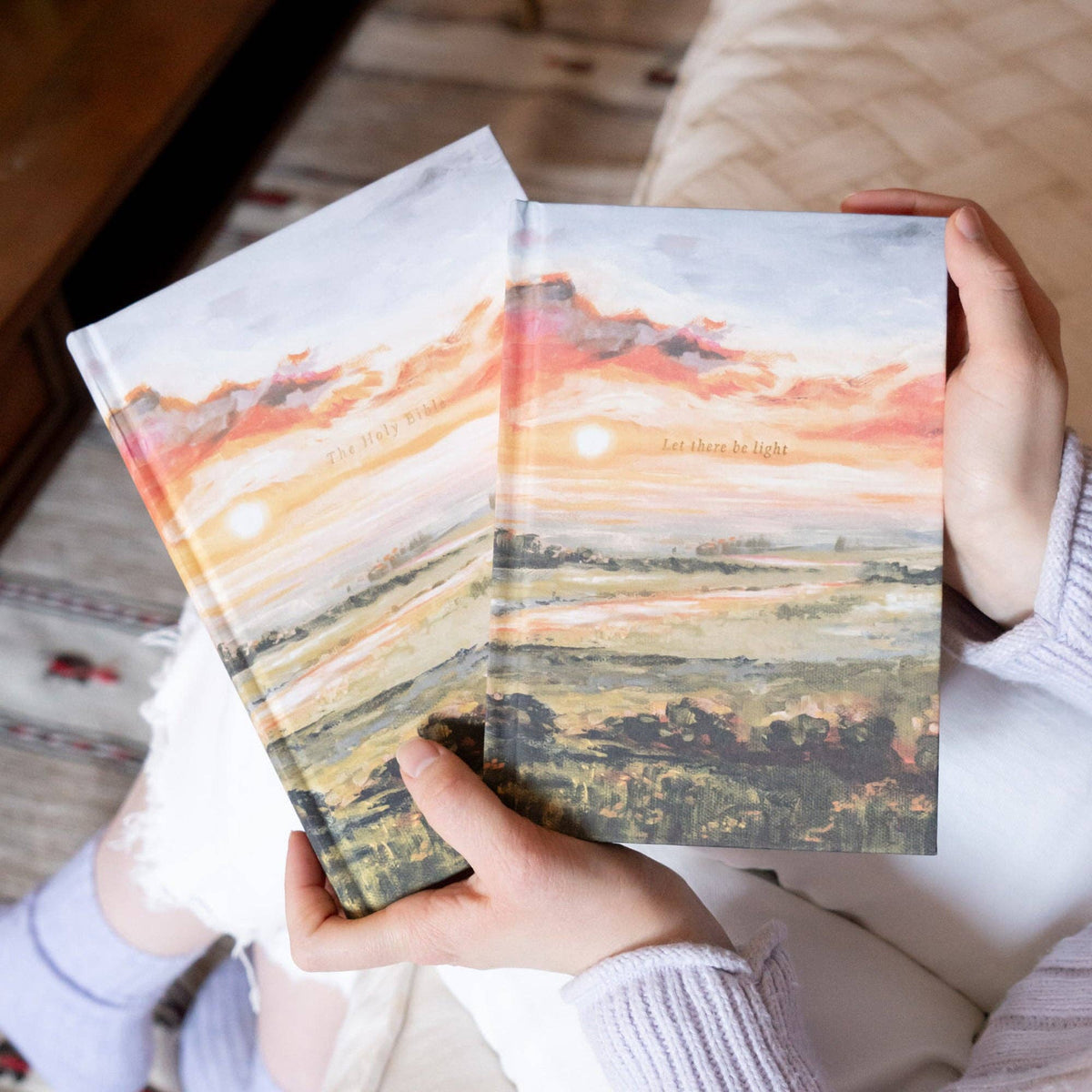 Two sunset notebooks held in hand, front covers showing