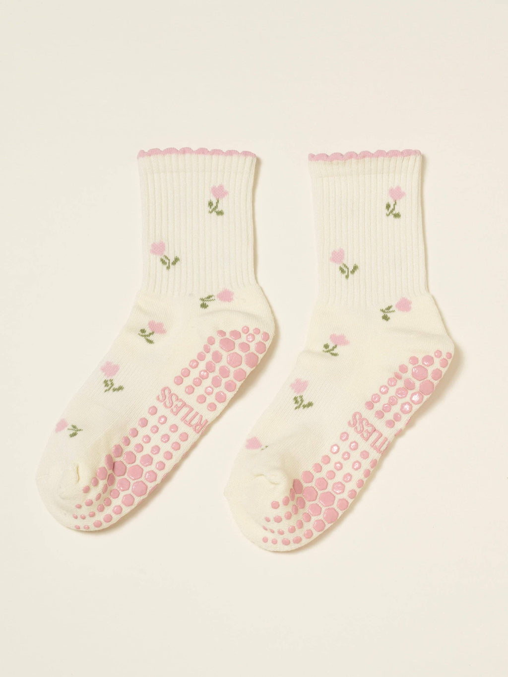 Pair of cream tulip socks laid flat with pink grip soles