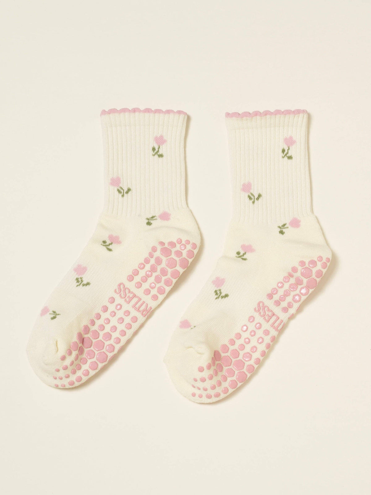 Pair of cream tulip socks laid flat with pink grip soles