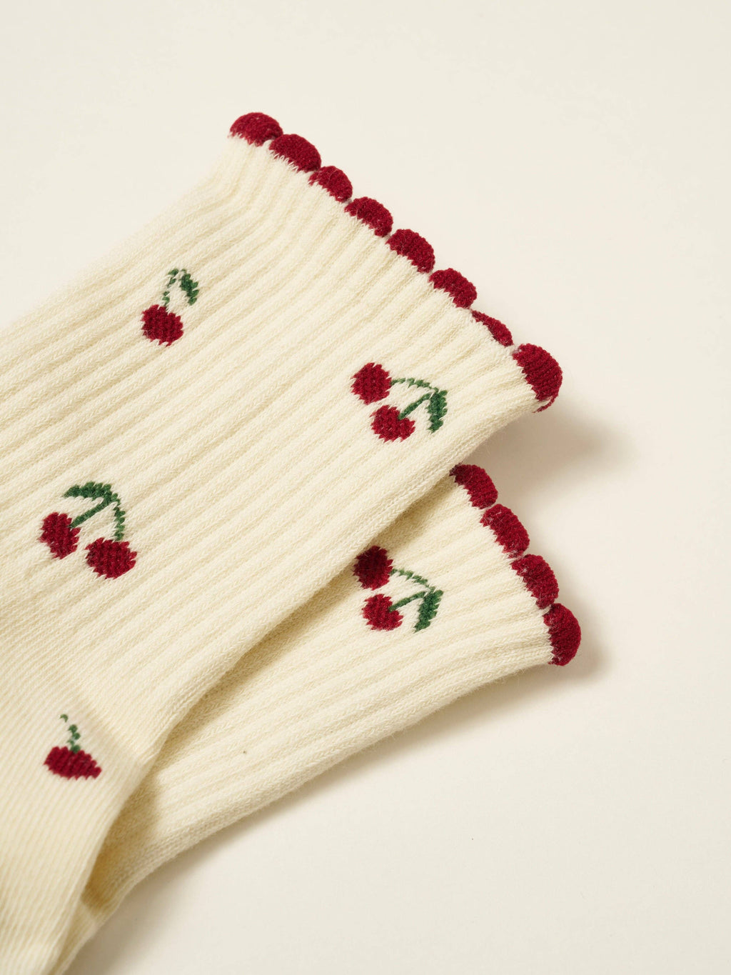Close view of the cherry motif and red scalloped cuff