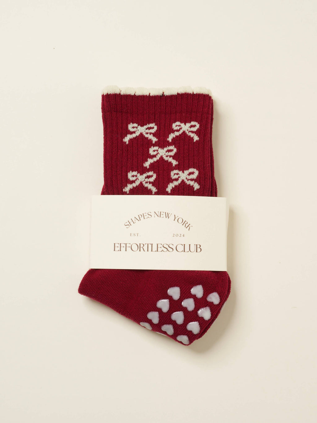 Burgundy grip socks with cream bows and a cream scalloped cuff, folded in their band