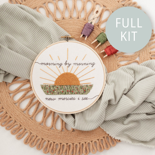 Finished hoop: "morning by morning new mercies I see" around a stitched sunrise over a field
