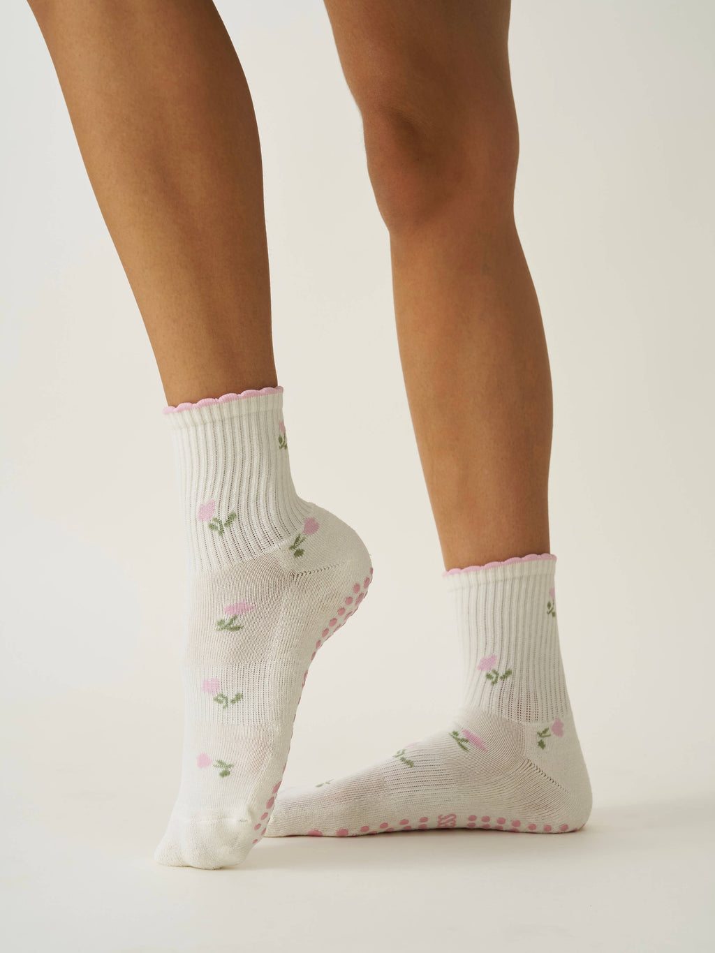 The cream tulip grip socks worn, showing the pink grip dots underfoot