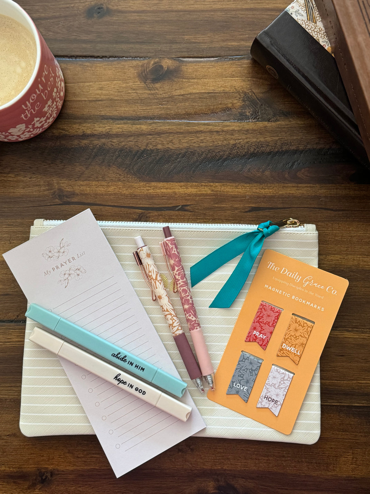 Study bundle laid on a striped zip pouch: a prayer list pad, two pens, two highlighters and magnetic bookmarks