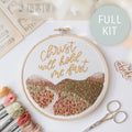 Finished hoop: "Christ will hold me fast" in gold script above stitched rolling hills and a path
