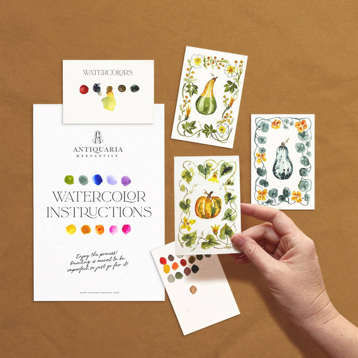 Mini gourds watercolor kit: instructions, paint card and three gourd designs, one held in hand