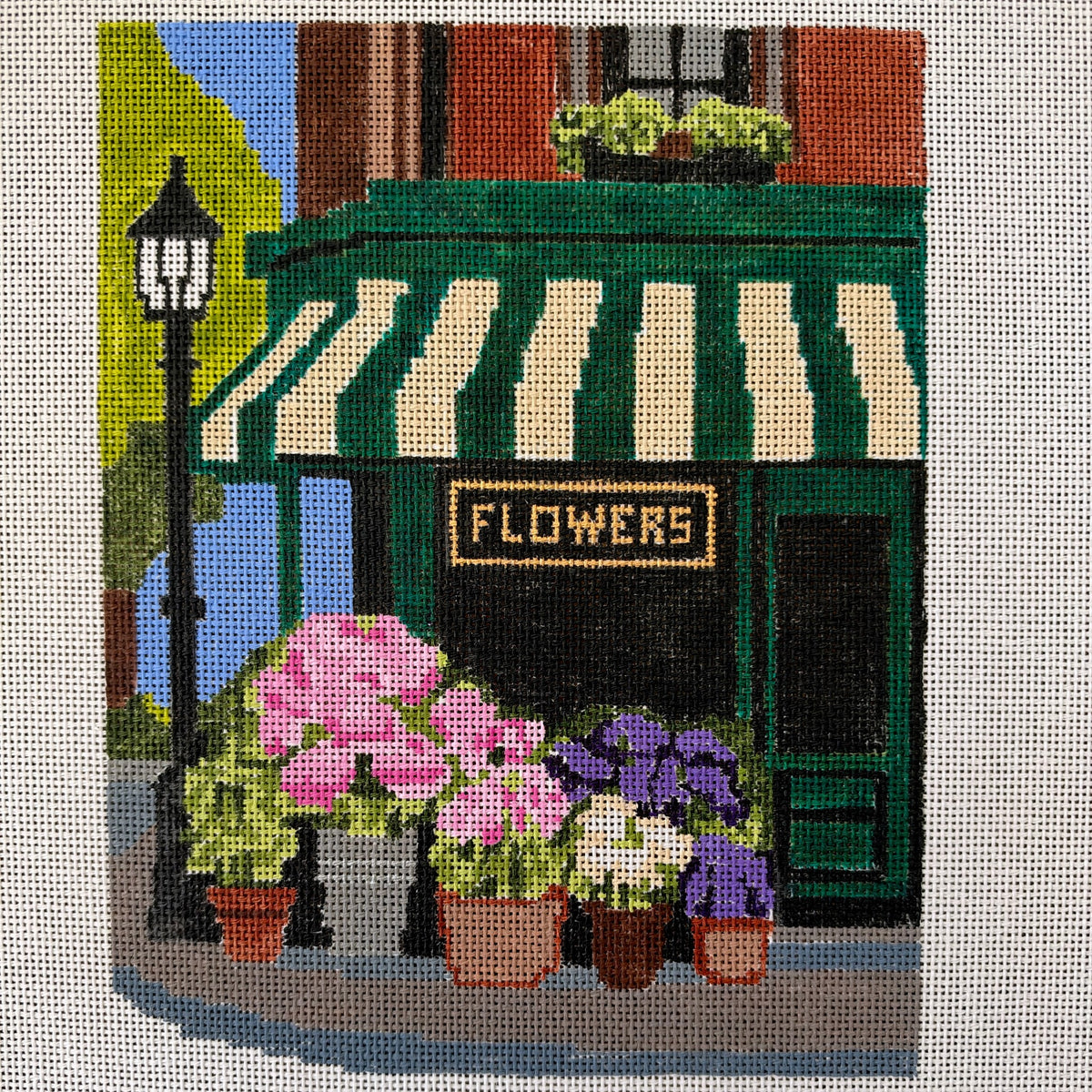 A hand-painted Corner Flower Shop needlepoint canvas from the Storybook series