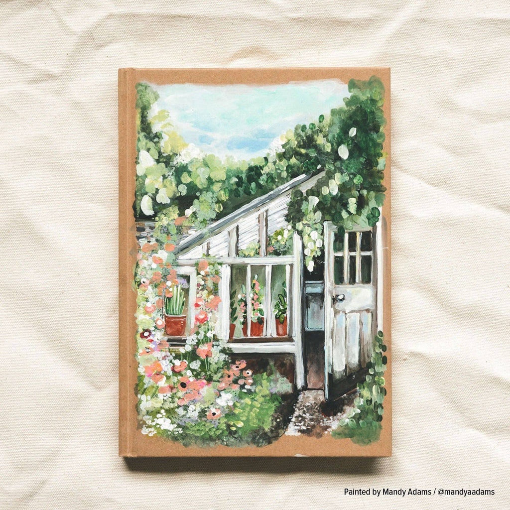 Example of a painted cover: a garden greenhouse among flowers, painted onto the kraft notebook