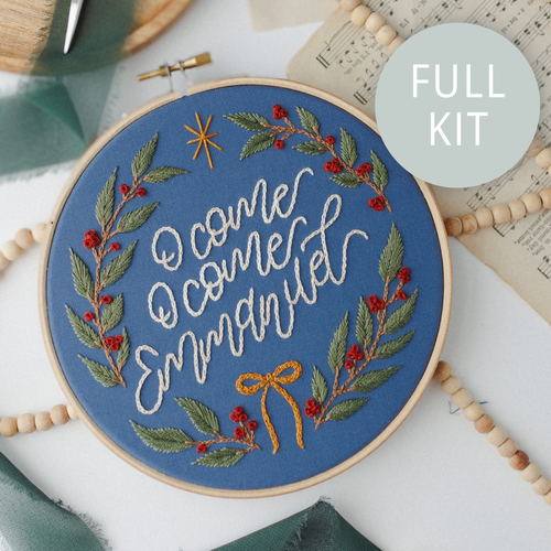 Finished hoop on navy fabric: "O come, O come Emmanuel" in cream script inside a holly and berry wreath