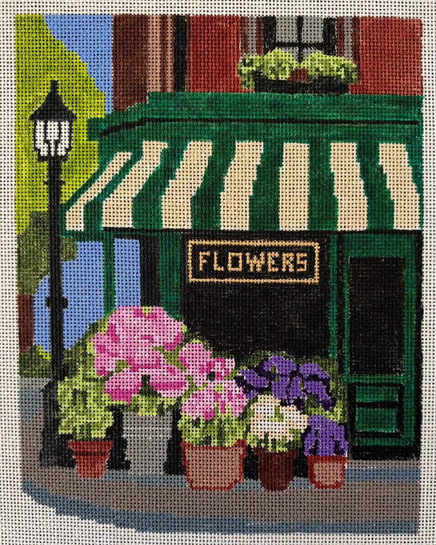 Corner Flower Shop needlepoint canvas being painted, from blank mesh to the awning, the building, the sign, and the finished canvas