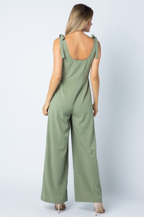 Back view of the sage jumpsuit with its scoop back and tie straps