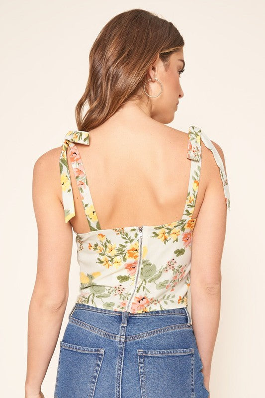 Back view of the floral top with bow-tied straps and a low square back