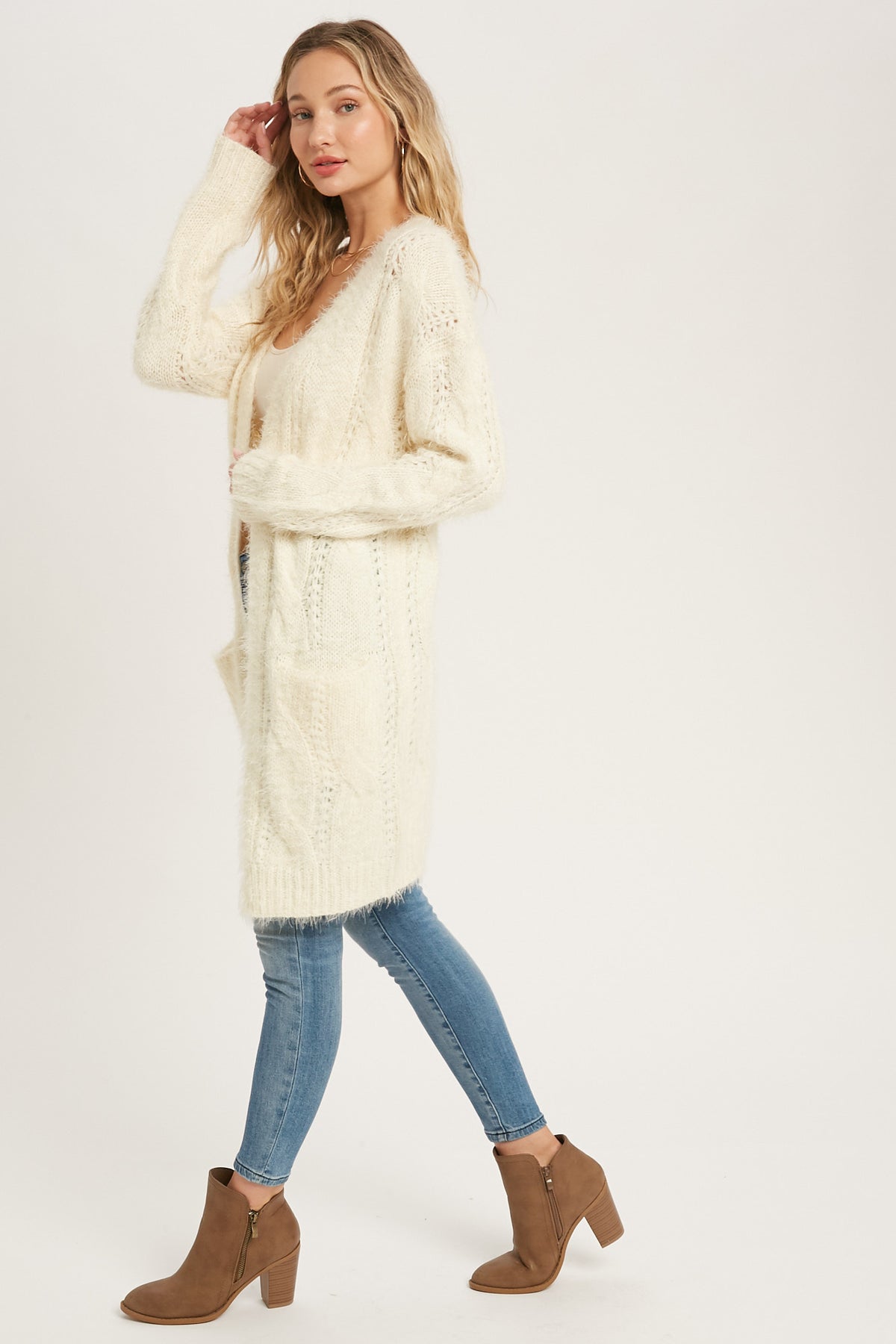 Side view of the ivory long cardigan with jeans and ankle boots