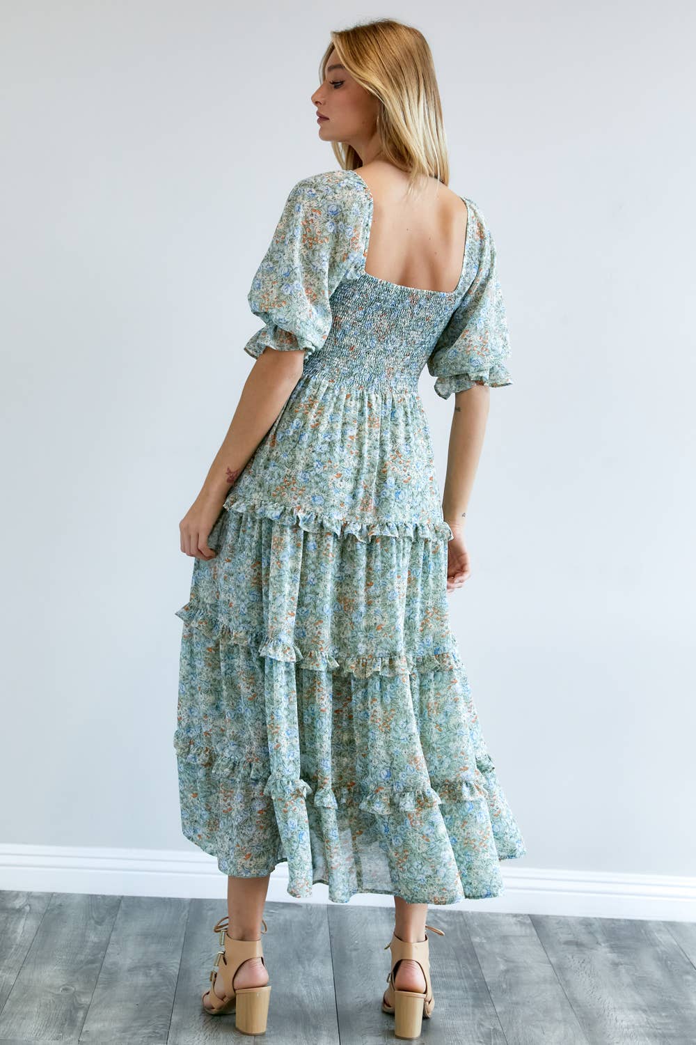 Back view of the floral midi dress's smocked bodice and ruffled tiers