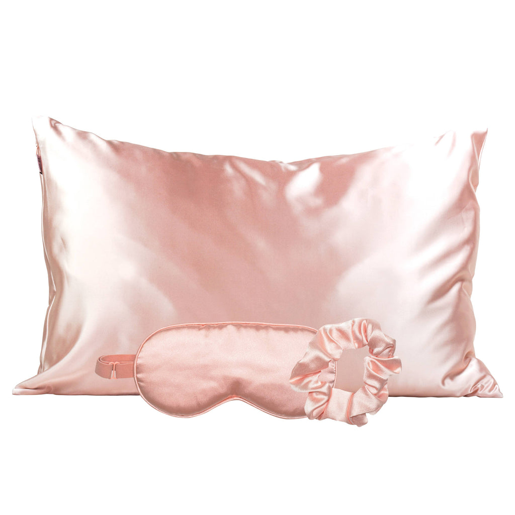Blush pink satin pillowcase with a matching sleep mask and scrunchie
