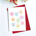 Greeting card of pastel candy conversation hearts: Be mine, XOXO, Miss you and more