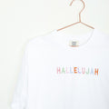 White tee with "HALLELUJAH" in multicolored pastel letters, on a hanger