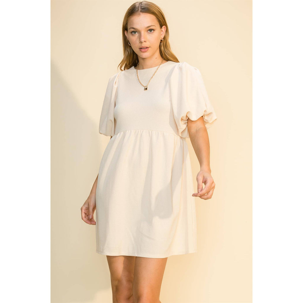 Closer front view of the cream dress's puff sleeves and empire waist