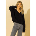 Black chenille V-neck sweater with a relaxed fit, worn with gray jeans