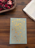 Blue journal with "be still" in gold foil inside a floral border