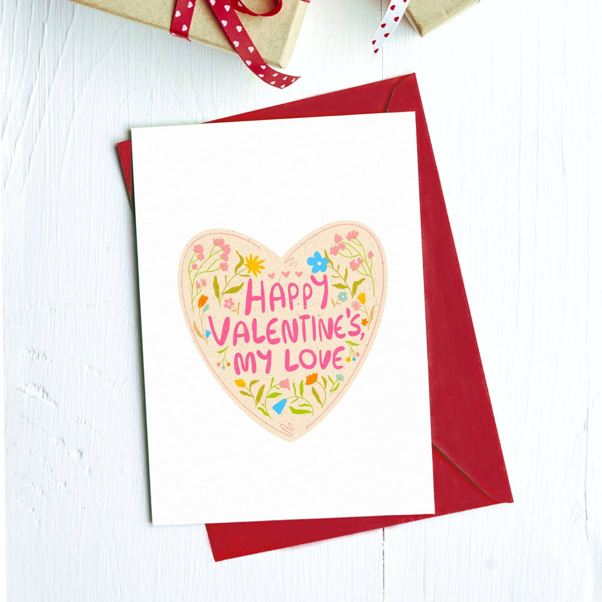 Greeting card with a floral heart reading "Happy Valentine's my love" on a red envelope